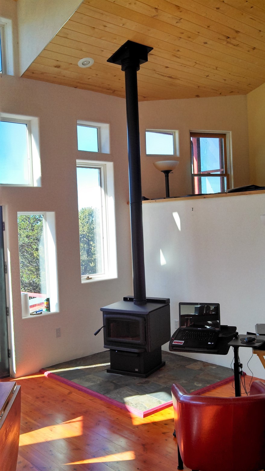 A wood burning stove with tall chimney installed by Shangrilah Stove LLC..